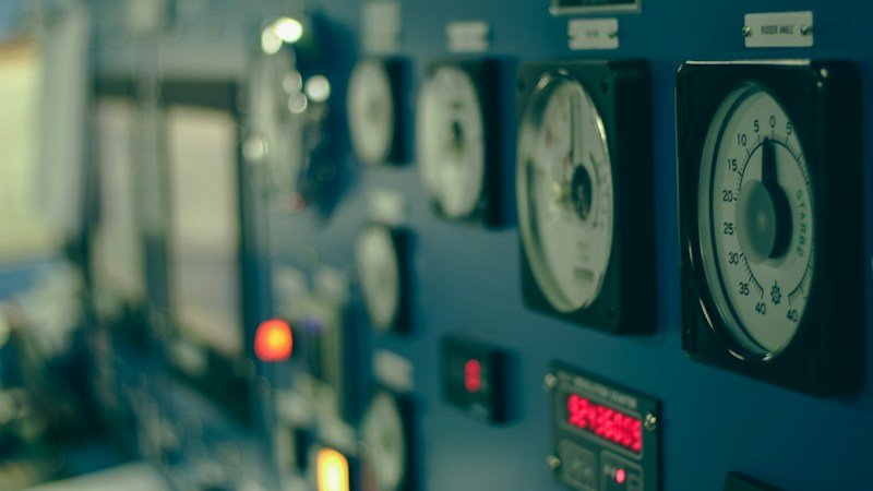 Close-up de painel de controle industrial com mostradores e indicadores