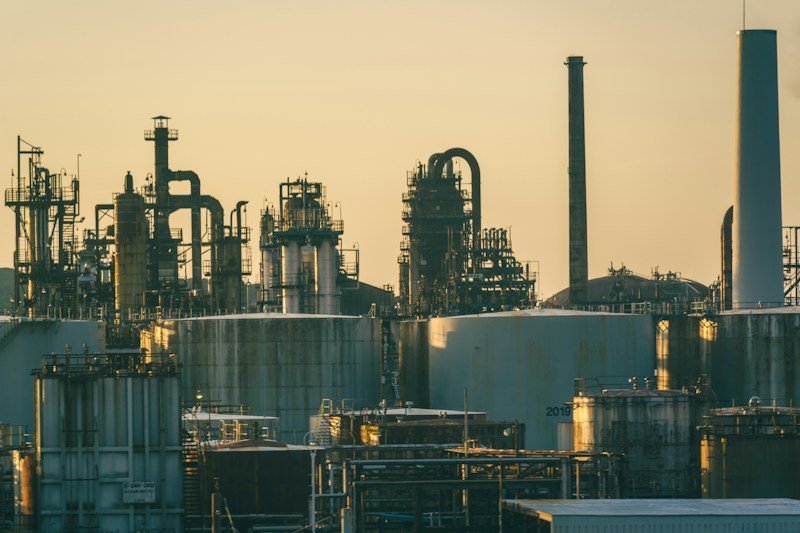 Refinaria industrial com tanques de armazenamento ao entardecer